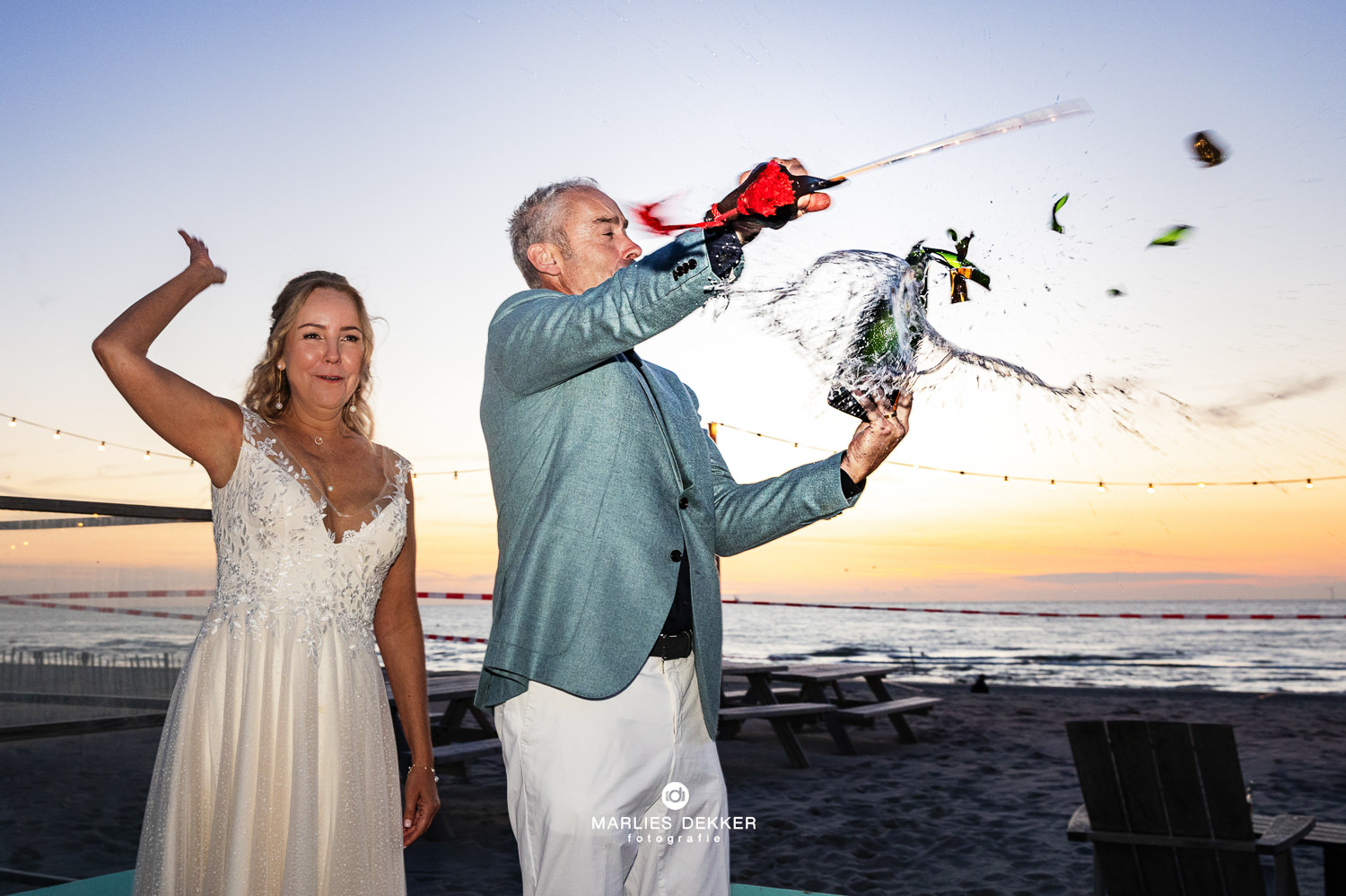 Trouwen in Scheveningen bij Strandhuis mavi , de fles champagne wordt gesabreerd